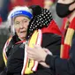 Seorang suporter menggunakan pelindung wajah saat menyaksikan pertandingan antara Liverpool kontra Wolverhampton Wanderers  pada laga Liga Inggris di Stadion Anfield, Minggu (6/12/2020). (Peter Powell/Pool via AP)