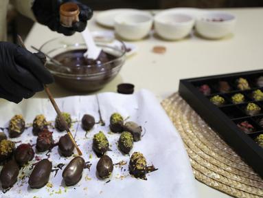 Wanita Palestina bernama Sojood Silwadi membuat kurma berlapis cokelat di rumahnya di Kota Nablus, Tepi Barat, 15 November 2020. Silwadi (26) merintis proyeknya setahun lalu. (Xinhua/Ayman Nobani)