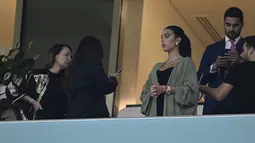 Georgina Rodriguez  menghadiri pertandingan babak 16 besar Piala Dunia Qatar 2022 antara Portugal dan Swiss di Stadion Lusail di Lusail, utara Doha (6/12/2022). Georgina Rodriguez juga terlihat cantik mengenakan mantel cokelat dan mengikat rambutnya. (AFP/Patricia De Melo Moreira)