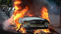 Sebuah mobil terbakar dalam unjuk rasa menentang penyelenggaraan Konferensi Tingkat Tinggi (KTT) G20 di Hamburg, Jerman, Kamis (6/7). Sejumlah pemimpin dunia berkumpul dalam KTT G20 di Hamburg pada 7-8 Juli 2017. (Christophe Gateau/dpa via AP)