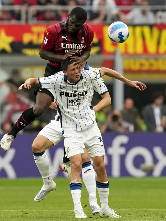 Pemain AC Milan Franck Kessie melompat ke atas pemain Atalanta Matteo Pessina pada pertandingan sepak bola Serie A di Stadion San Siro, Milan, Italia, 15 Mei 2022. AC Milan menang 2-0. (AP Photo/Antonio Calani)