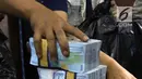 Petugas BNN menunjukkan barang bukti uang hasil tindak pidana pencucian uang (TPPU) di Jakarta, Selasa (17/7). TPPU ini terbongkar dari pengembangan kasus napi bernama Irawan alias Dagot di Rutan kelas 11A Pontianak. (Liputan6.com/Arya Manggala)