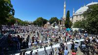Umat Muslim berdoa saat menunaikan salat Jumat dengan latar belakang situs bersejarah Hagia Sophia di distrik bersejarah Sultanahmet di Istanbul, Jumat (24/7/2020). Hari ini, Hagia Sophia menyambut umat Islam melaksanakan salat Jumat pertama dalam 86 tahun.(AP Photo/Yasin Akgul)