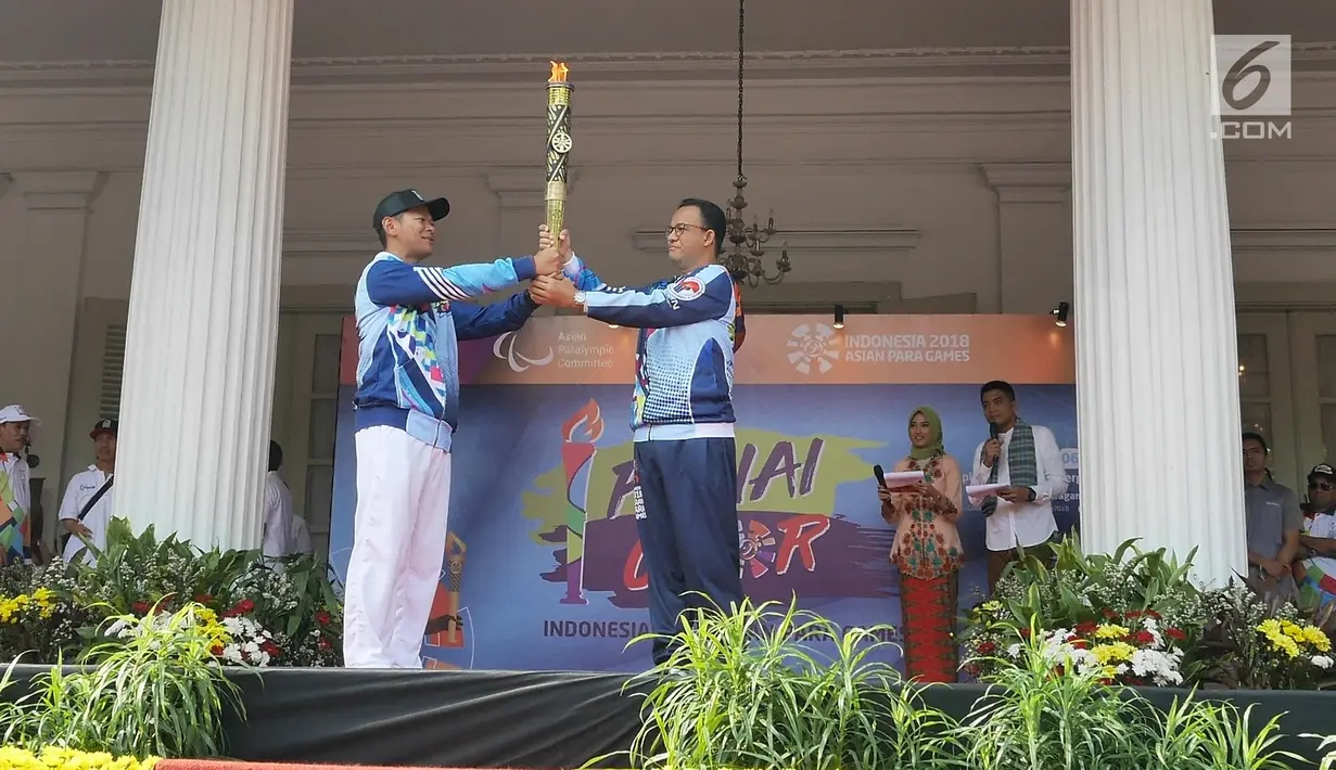 Ketua Umum INAPGOC Raja Sapta Oktohari (kiri) menyerahkan api obor Asian Para Games 2018 kepada Gubernur DKI, Anies Baswedan di Balai Kota DKI Jakarta, Minggu (30/9). Api obor ini akan diarak di 17 titik lokasi di Ibu Kota. (Liputan6.com/Herman Zakahria)