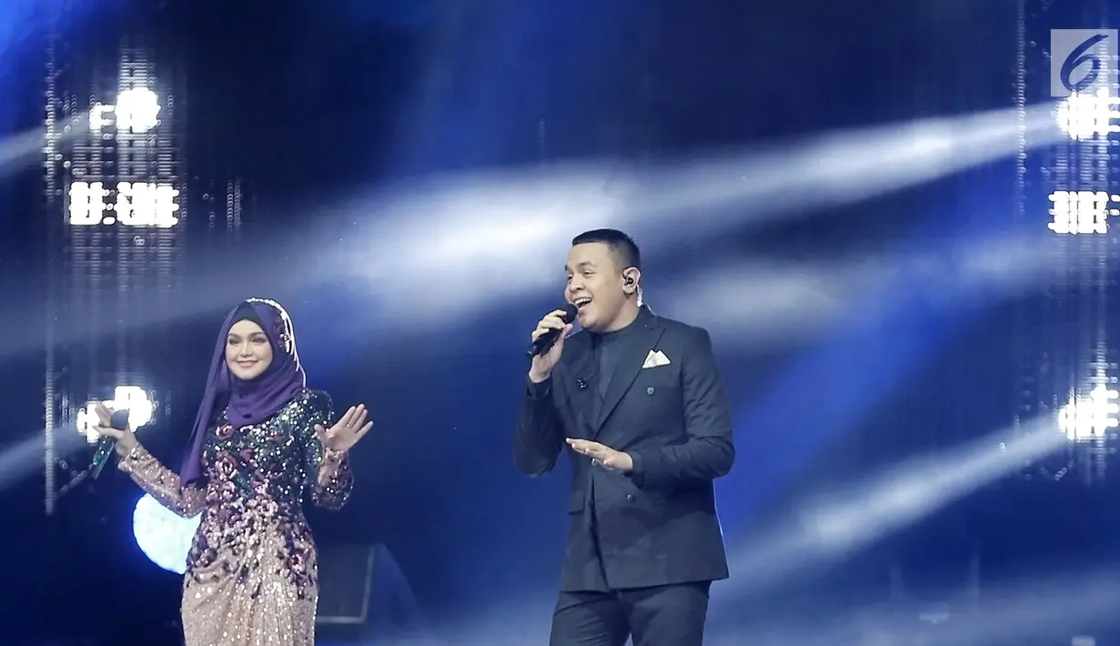 Penyanyi Siti Nurhaliza (kiri) berduet dengan Tulus dalam konser 'Dato Sri Siti Nurhaliza on Tour' di Istora Senayan, Jakarta, Kamis (21/2). Kehadiran Tulus menjadi kejutan spesial bagi penonton konser tersebut. (Fimela.com/Bambang E Ros)