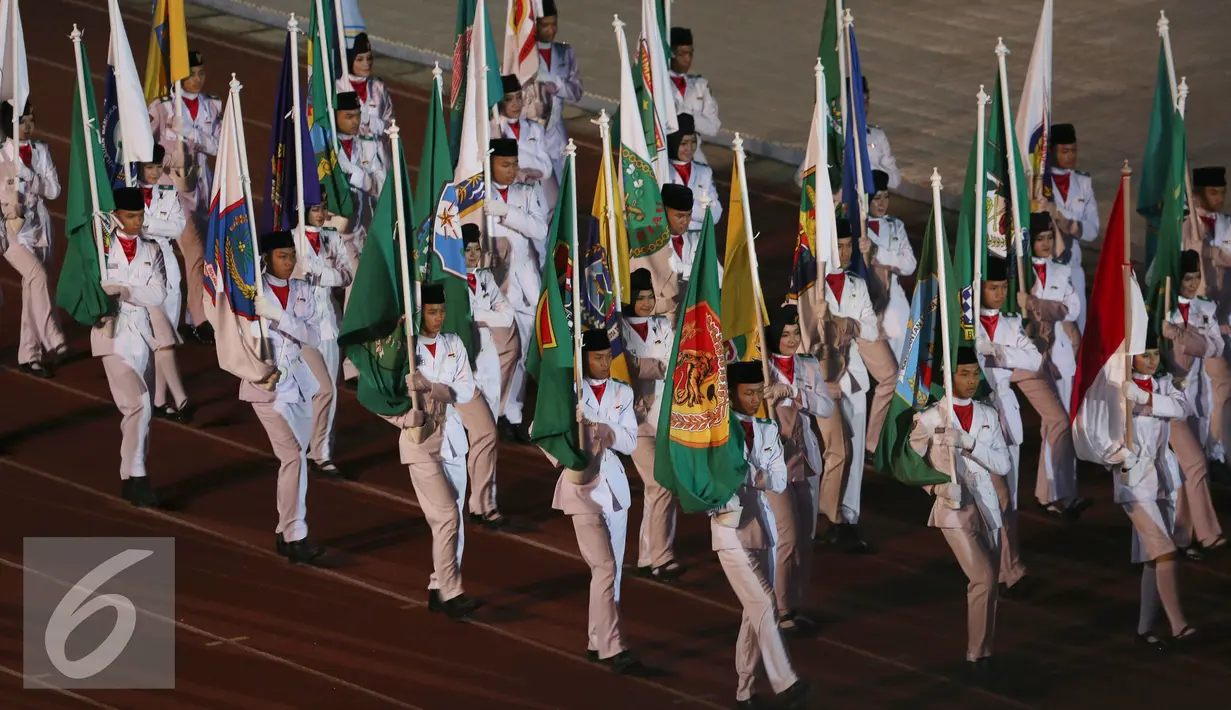 Anggota Paskibra membawa bendera kontingen saat defile peserta PON XIX Jabar di Stadion Gelora Bandung Lautan Api, Bandung, Sabtu (17/9). 9.533 atlet akan berlaga di 44 cabang olahraga. (Liputan6.com/Helmi Fithriansyah)