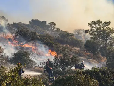 Petugas pemadam kebakaran berupaya memadamkan kebakaran hutan yang terjadi di Ierapetra, pulau Kreta, Yunani selatan, pada Kamis 3 Juli 2025. (Costas Metaxakis/AFP)