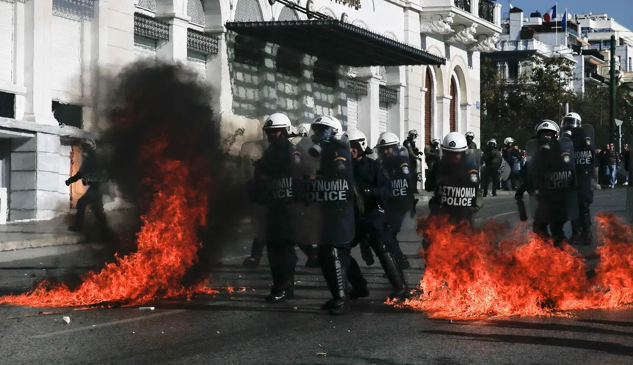 Sejumlah polisi anti huru-hara melawan aksi demonstran yang melemparkan bom api di Athena, Yunani, (12/11/2015). Para Demonstran memprotes langkah-langkah penghematan yang diminta oleh badan pinjaman internasional. (REUTERS/Alkis Konstantinidis)