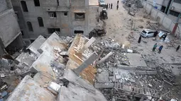 Serangan Israel ini diluncurkan meski perjanjian gencatan senjata antara kedua pihak berseteru masih berlaku. Tampak dalam foto, warga Palestina yang mengungsi memeriksa kerusakan setelah pesawat Israel menargetkan sebuah rumah berlantai lima tadi malam, di Khan Yunis, Jalur Gaza selatan, pada Kamis 6 Februari 2026. (Bashar Taleb/AFP)