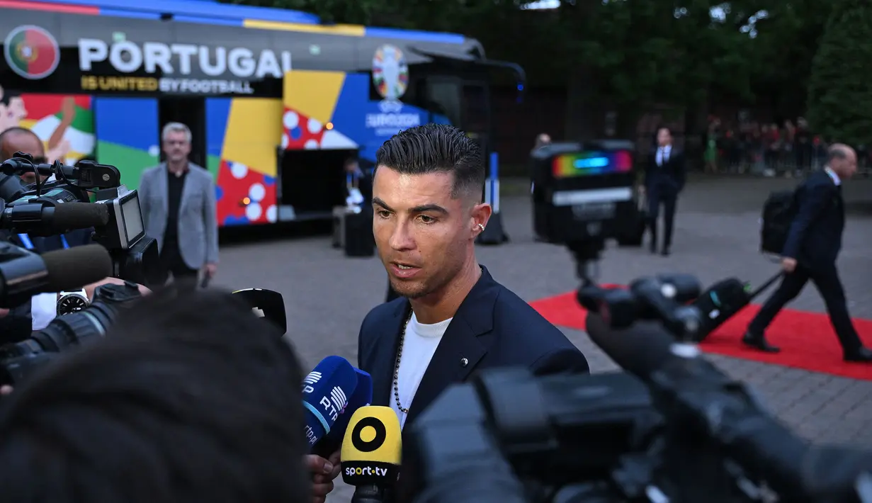 Pemain Timnas Portugal, Cristiano Ronaldo memberikan keterangan kepada awak media saat tiba di hotel tempat menginap jelang Euro 2024 di Harsewinkel, Jerman, Rabu (13/06/2024) waktu setempat. (AFP/Patricia De Melo Moreira)