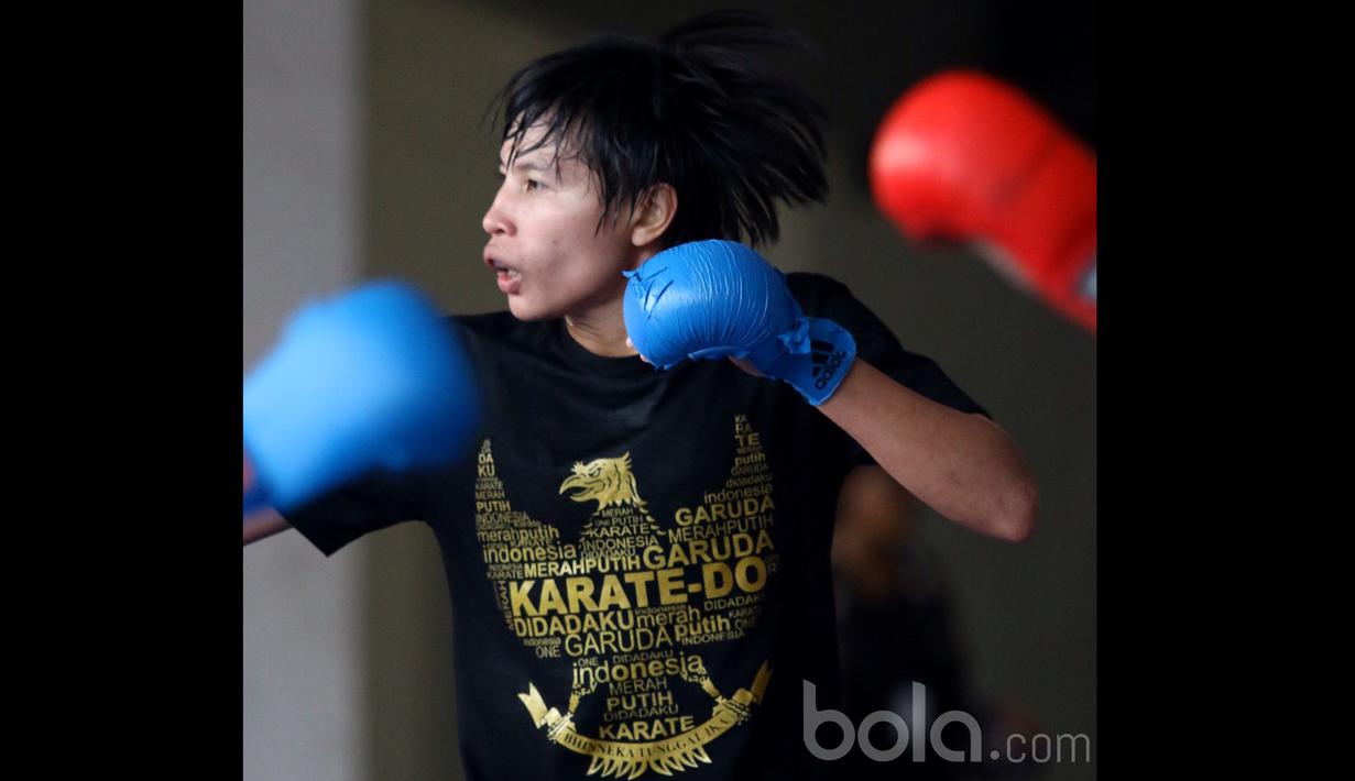 Seorang Karateka Putri dengan kaos bergambar garuda tengah berlatih mematangkan pukulan di Senayan, Jakarta, (Bola.com/Nicklas Hanoatubun)