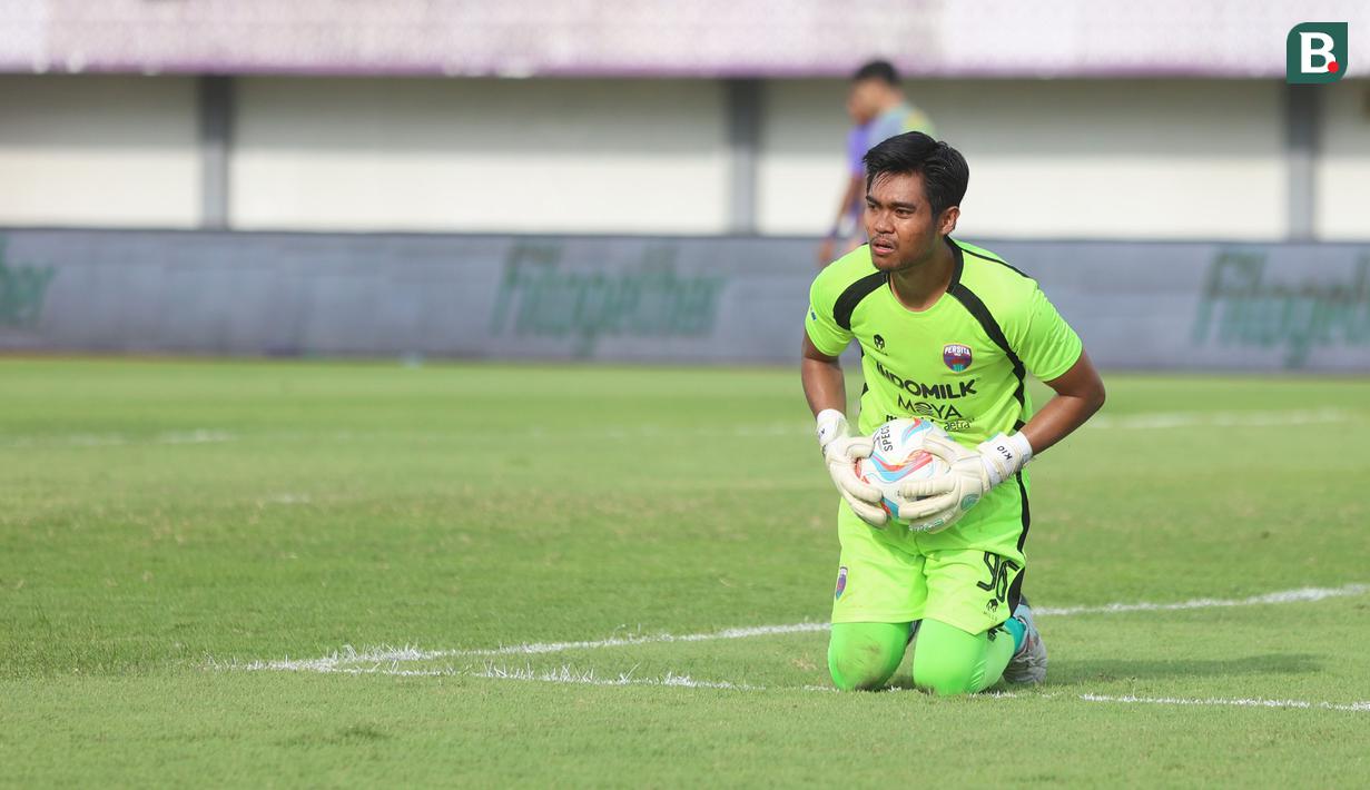 <p>Kiper Persita Tangerang, Kurniawan Kartika Ajie berhasil menangkap bola saat menghadapi Persebaya Surabaya pada laga pekan ke-25 BRI Liga 1 2023/2024 di Stadion Indomilk Arena, Tangerang, Jumat (23/2/2024). (Bola.com/M Iqbal Ichsan)</p>