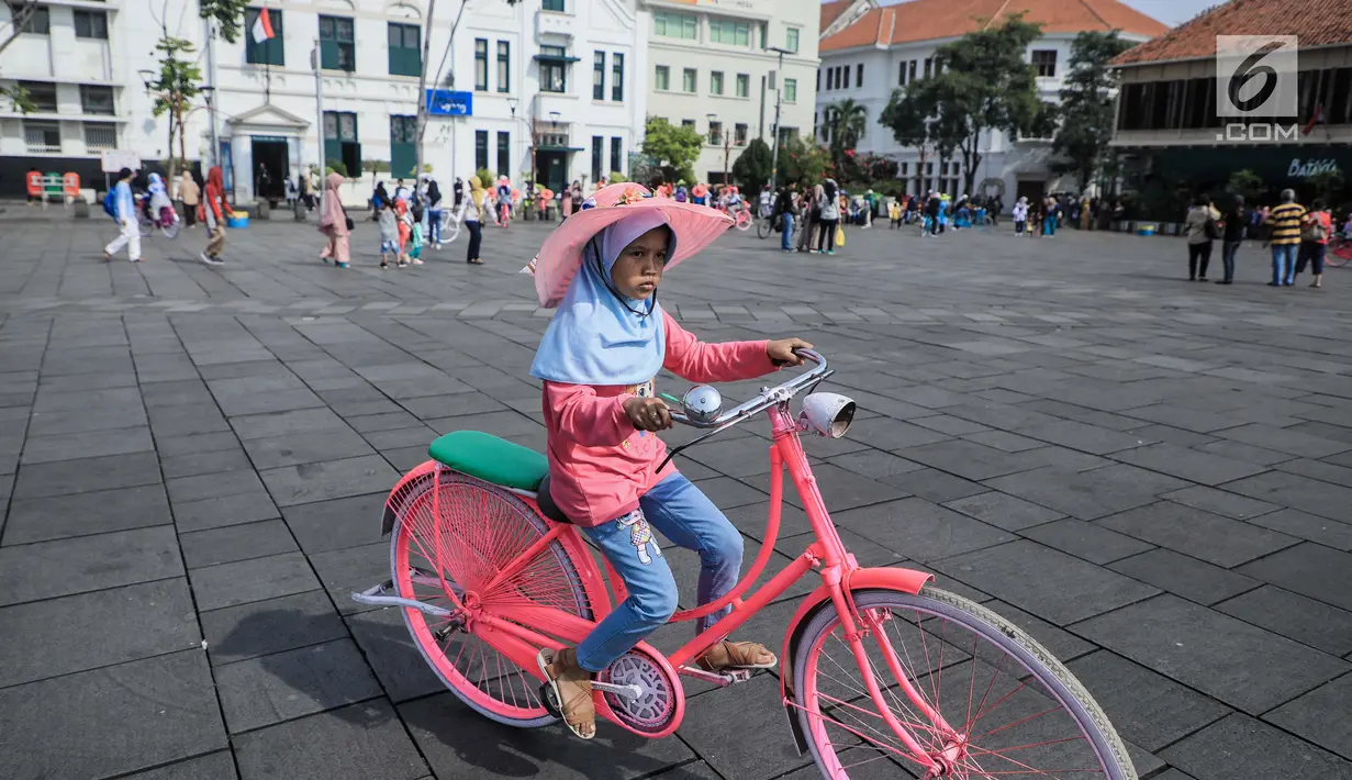 Pengunjung bersepeda mengelilingi kawasan Kota Tua, Jakarta, Sabtu (8/6/2019). Selama libur lebaran 2019, sejak 7 Juni kemarin hingga beberapa hari kedepan, jam berkunjung ke berbagai museum di kawasan wisata sejarah Kota Tua diperpanjang hingga pukul 20.00 WIB. (Liputan6.com/Faizal Fanani)