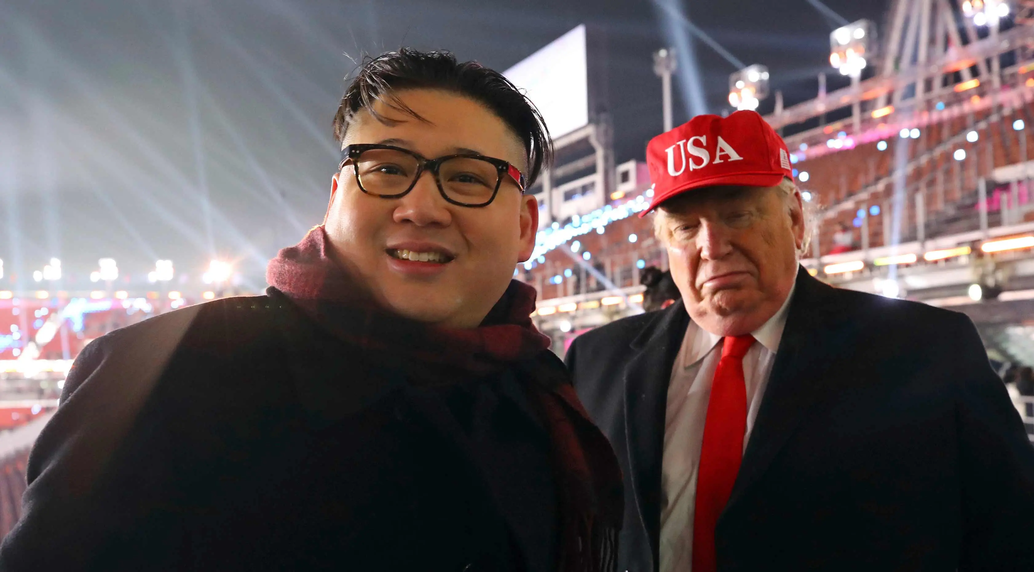 Dua pria berpakaian seperti pemimpin Korea Utara Kim Jong Un (kiri) dan Presiden AS, Donald Trump berpose bersama saat menghadiri upacara pembukaan Olimpiade Pyeongchang 2018 di Pyeongchang, Korea Selatan (9/2). (Jo Hyun-woo / Yonhap via AP)