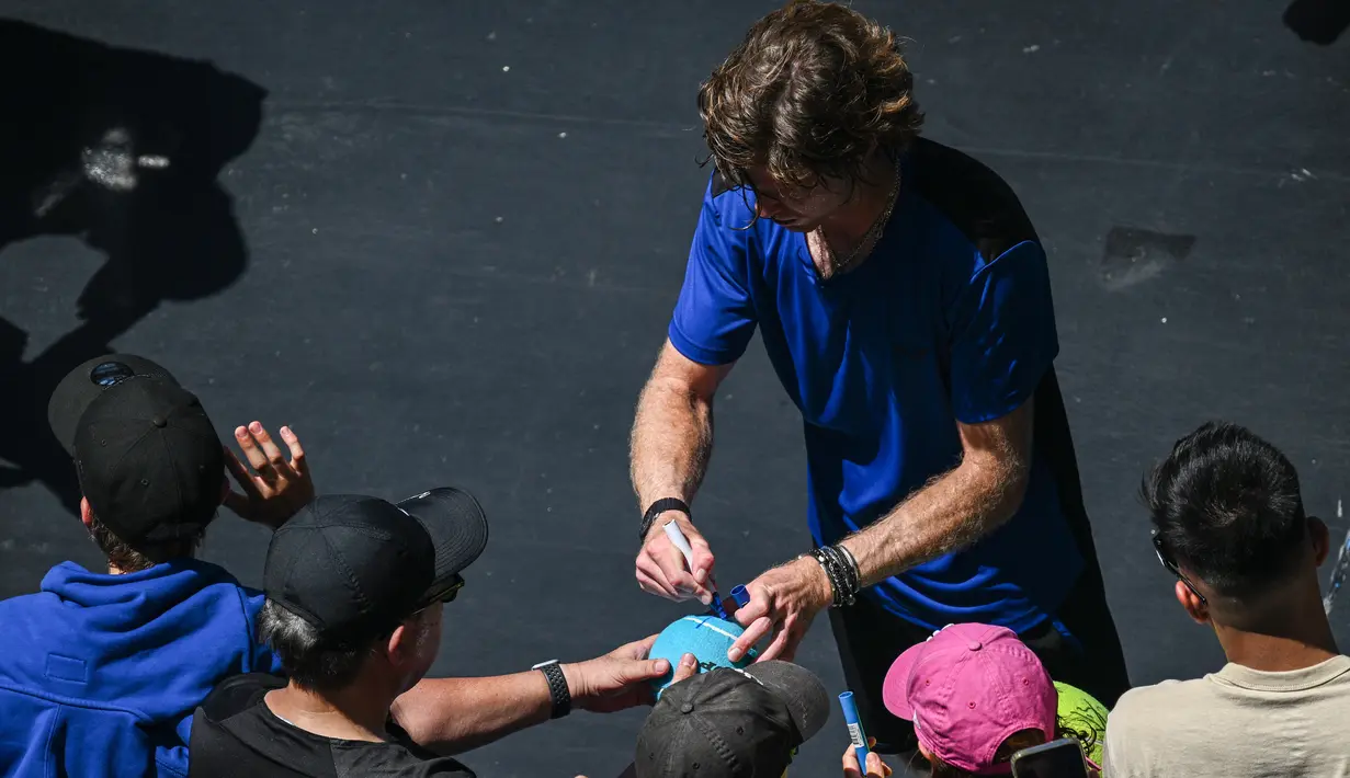 Petenis asal Rusia Andrey Rublev memberikantanda tangan setelah kemenangannya melawan Dominic Thiem dari Austria selama pertandingan tunggal putra mereka pada hari kedua Australia Terbuka di Melbourne, Selasa (17/1/2023). Berburu tanda tangan menjadi salah satu aktivitas fans yang menonton langsung Australian Open 2023. (ANTHONY WALLACE / AFP)