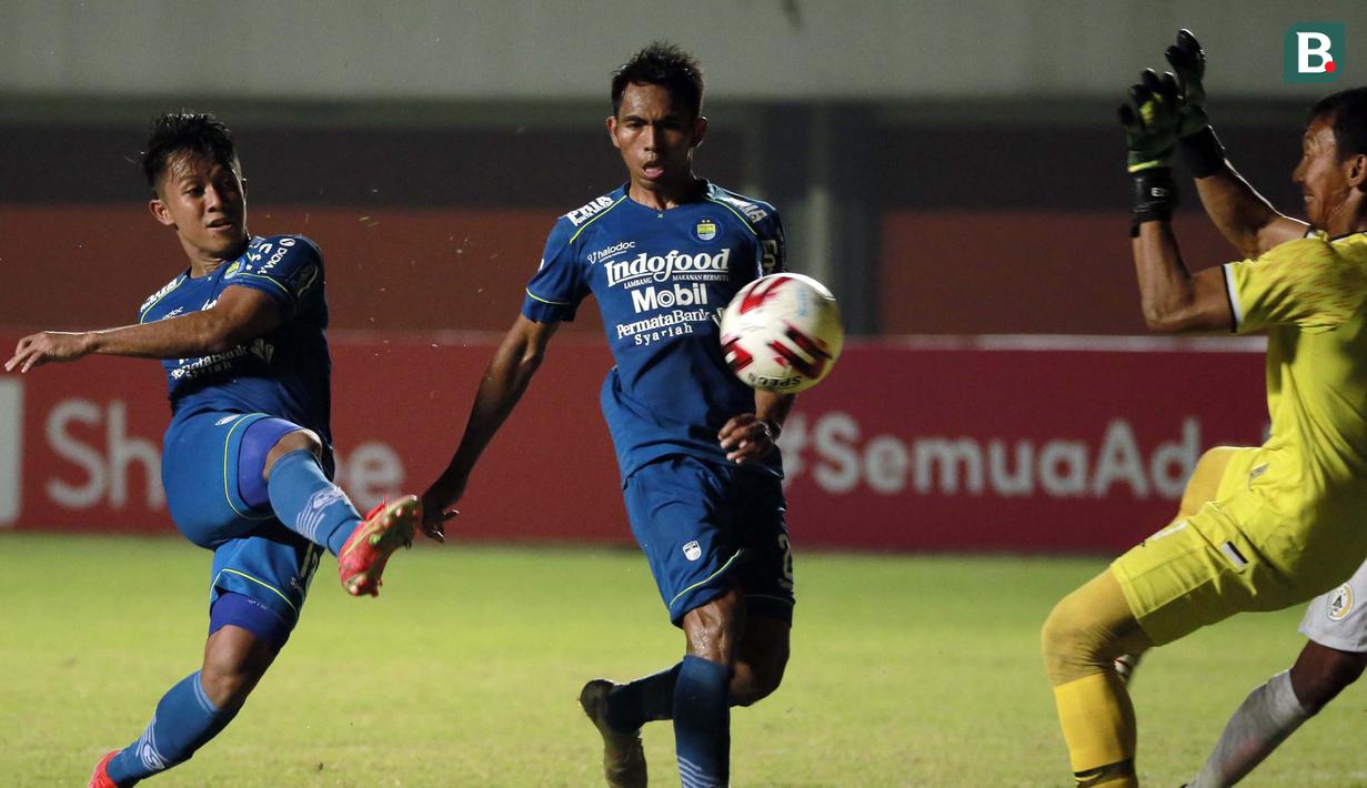 Pemain Persib Bandung, Febri Hariyadi (kiri) melepaskan tendangan ke gawang PS Sleman yang dikawal kiper Ega Rizky Pramana dalam laga leg pertama semifinal Piala Menpora 2021 di Stadion Maguwoharjo, Sleman, Jumat (16/4/2021). Persib menang 2-1 atas PS Sleman. (Bola.com/Ikhwan Yanuar)
