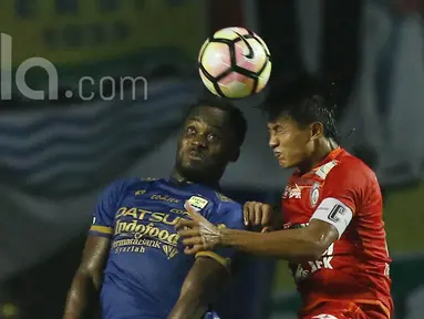 Gelandang Persib Bandung, Michael Essien, duel udara dengan kapten Arema FC, Johan Alfarizi dalam laga pembuka Liga 1  antara Persib Bandung melawan Arema  FC di GBLA, Sabtu (15/04/2017). Skor berakhir imbang 0-0. (Bola.com/M Iqbal Ichsan).