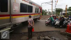 Sebuah kereta Commuter Line melintas di perlintasan kereta api Bintaro, Jakarta, Senin (16/1). Untuk mengurangi angka kecelakaan di perlintasan kereta api, Pemerintah Provinsi DKI Jakarta akan membangun jalan layang. (Liputan6.com/Gempur M. Surya)