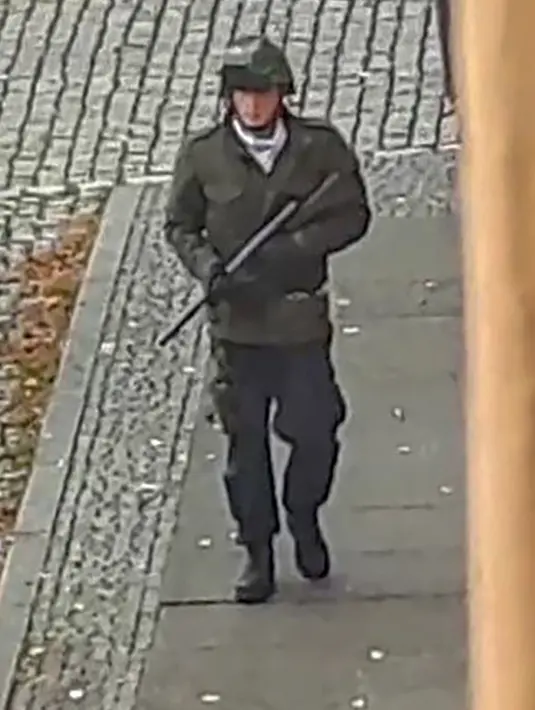 Seorang pria berjalan membawa senjata di jalanan Halle an der Saale, Halle, Jerman, Rabu (9/10/2019). Selain melepaskan tembakan, pelaku juga sempat melemparkan sebuah granat tangan ke pemakaman Yahudi. (Andreas Splett/ATV-Studio Halle/AFP)