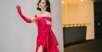 Prilly Latuconsina tampil begitu dramatis dalam foto ini. Dibalut gaun merah dengan bahu terbuka dan potongan tinggi pada bagian roknya, penampilan Prilly semakin megah dengan tambahan detail long gloves berwarna senada dan high heels netral. Foto: Instagram.