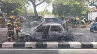 Petugas DPKP Kota Depok memadamkan api yang membakar mobil di Jalan Raya Margonda. Kebakaran diduga dipicu korsleting listrik. (Liputan6.com/Dicky Agung Prihanto)