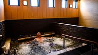 Seorang pria bersantai dalam kolam renang indoor di pemandian air panas Jepang atau onsen di Yokohama, prefektur Kanagawa pada 29 Mei 2020. Dengan pencabutan status darurat nasional pada Senin (25/5) lalu, banyak bisnis yang mulai beroperasi kembali tak terkecuali dengan onsen. (Behrouz MEHRI/AFP)