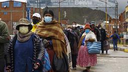 Warga Bolivia mengantre masuk ke perbatasan Peru untuk memasuki negara tersebut, di desa Desaguadero, Bolivia, pada 18 Februari 2022. Setelah ditutup selama hampir dua tahun karena pandemi Covid-19, Peru mengizinkan pembukaan kembali perbatasan dengan Bolivia dan Ekuador. (Carlos MAMANI/AFP)