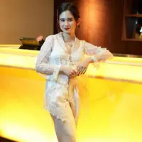 Tissa Biani tampil kasual mengenakan kebaya modern putih transparan dipadukan inner kutang warna senada serta celana panjang warna beigenya. [@tissabiani]