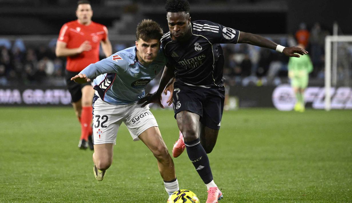 Hingga babak pertama usai, skor imbang 1-1 tidak berubah. Tampak dalam foto, penyerang Real Madrid asal Brasil, Vinicius Junior (kanan) berebut bola dengan bek Celta Vigo asal Spanyol, Javier Rodriguez pada pertandingan pekan ke-27 La Liga 2025/2026 di Estadio Abanca-Balaidos pada Jumat 6 Maret 2026 waktu setempat atau Sabtu 7 Maret 2026 dini hari WIB. (Miguel RIOPA/AFP)