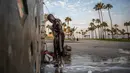 Jamal (hanya nama depan yang diberikan) yang telah hidup di jalanan selama 18 tahun, mandi di pancuran pantai umum di Venesia, California, Amerika Serikat, 12 Agustus 2021. (Apu GOMES/AFP)