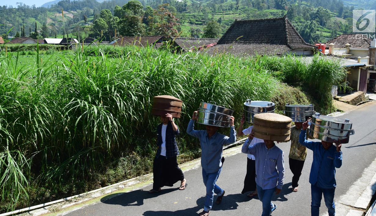 Warga membawa makanan menuju makam Desa Selo, Kabupaten Boyolali, Kamis (3/5). Tradisi ini Sebagai perayaan menyambut datangnya bulan ramadan, kemudian dilanjutkan makan bersama di pertigaan jalan desa. (Liputan6.com/Gholib)