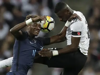 Striker Inggris, Tammy Abraham, berebut bola dengan bek Jerman, Antonio Rudiger, pada laga persahabatan di Stadion Wembley, London, Jumat (10/11/2017). Kedua negara bermain imbang 0-0. (AP/Matt Dunham)