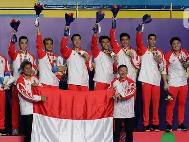 Pemain dan pelatih tim beregu putra Indonesia merayakan gelar juara cabang bulutangkis SEA Games 2019 di Multinlupa Sport Center, Manila, Rabu (4/12/2019). Indonesia mengunci medali emas usai mengalahkan Malaysia 3-1. (Bola.com/M Iqbal Ichsan)