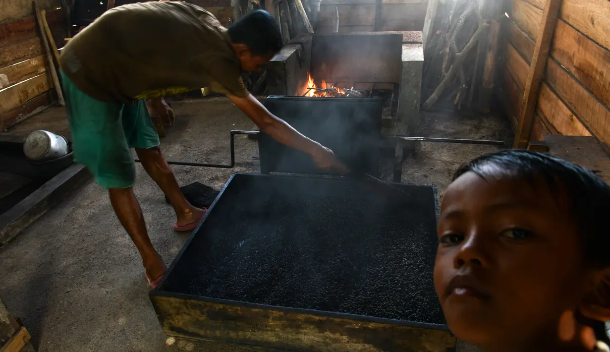 Seorang pria mengolah biji kopi robusta menggunakan alat tradisional di salah satu industri rumah tangga di Ulee Kareng, Aceh, Rabu (20/11/2019). Kopi yang diolah secara tradisional itu dijual dengan kisaran harga beragam tergantung kualitas. (CHAIDEER MAHYUDDIN/AFP)
