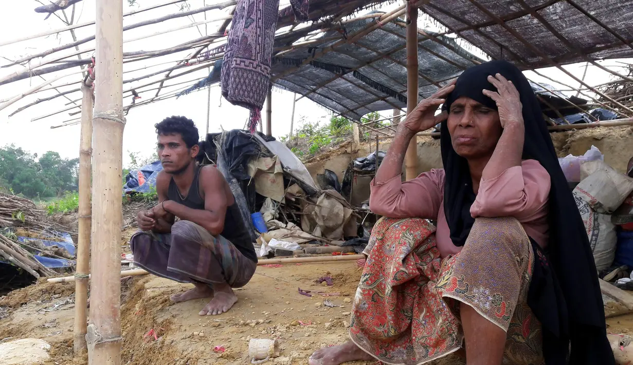 Pengungsi Rohingya duduk di sebuah tenda yang rusak akibat dihantam Topan Mora di sebuah kamp di distrik Cox's Bazar, Bangladesh (31/5). Ribuan rumah dan tenda-tenda yang beratap jerami di kamp tersebut hancur akibat Topan Mora. (AFP Photo/Str)