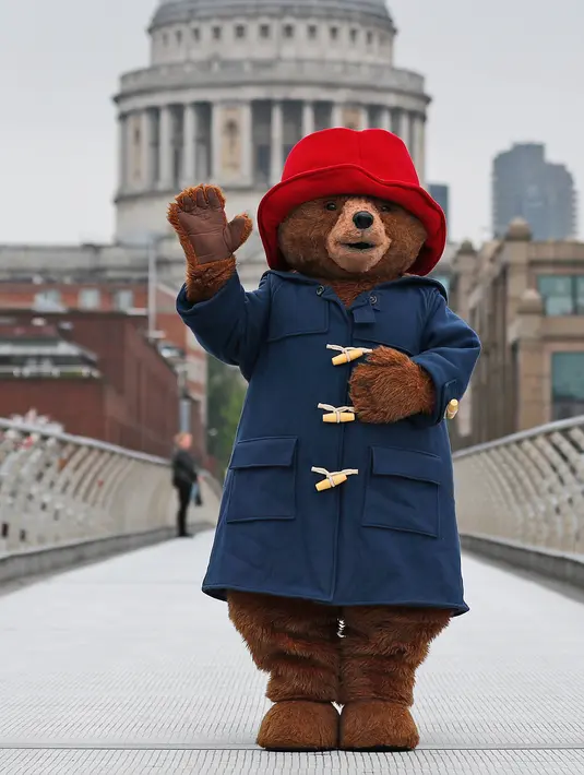 Seseorang yang mengenakan kostum Paddington Bear berpose dengan latar belakang Katedral St. Paul di London, Inggris (30/5). Paddington adalah karakter film berwujud beruang dari Peru yang melakukan perjalanan ke London. (AP/Frank Augstein)