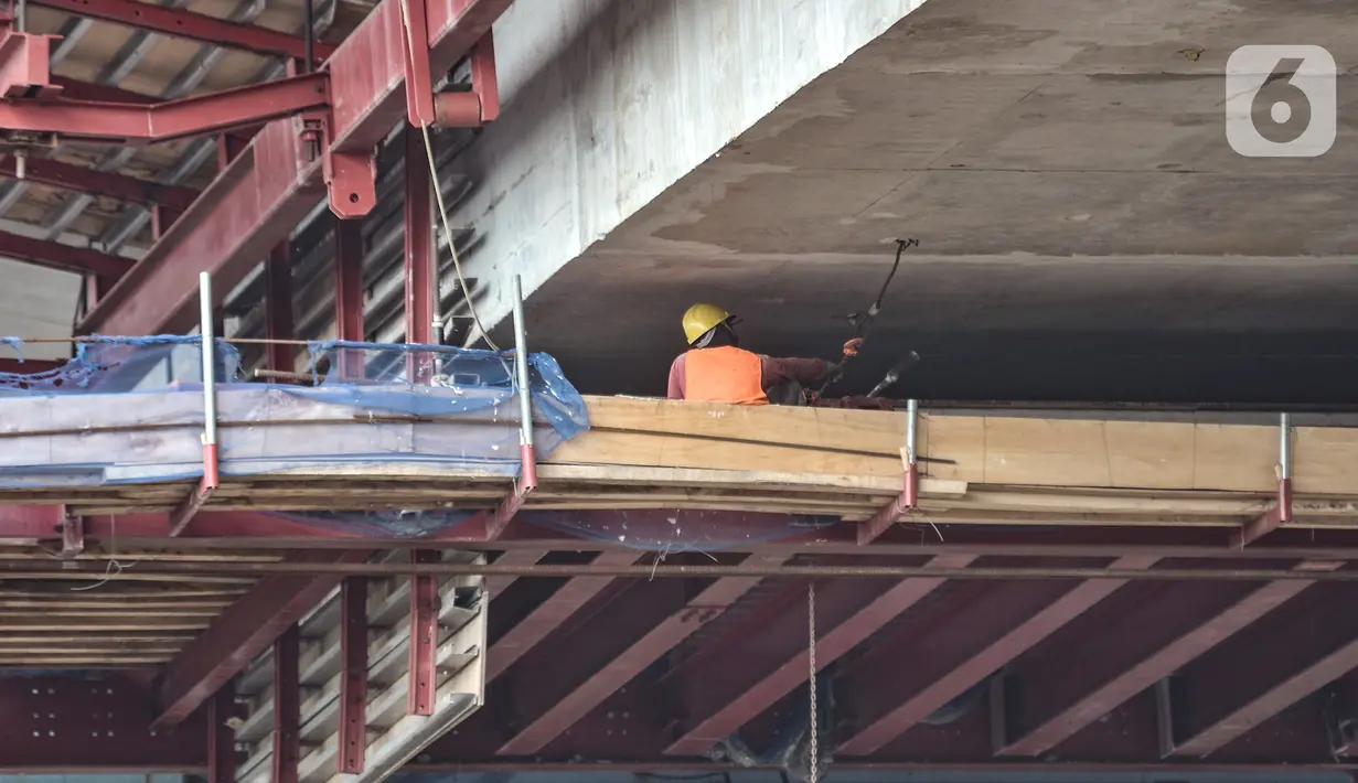 Pekerja menyelesaikan proyek Flyover Cakung, Jakarta, Kamis (17/12/2020). Flyover dengan biaya pembangunan mencapai Rp 261 miliar ini diharapkan mampu mengatasi kemacetan yang kerap terjadi di kawasan tersebut serta meminimalisir kecelakaan akibat perlintasan sebidang. (merdeka.com/Iqbal Nugroho)