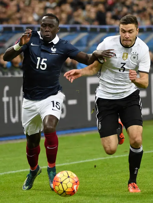 Bek Prancis, Bacary Sagna (kiri) berebut bola dengan bek Jerman Jonas Hector pada laga persahabatan antara Perancis melawan Jerman di stadion Stade de France, Perancis, (13/11). Perancis menang atas Jerman dengan skor 2-0. (AFP PHOTO/MIGUEL MEDINA)