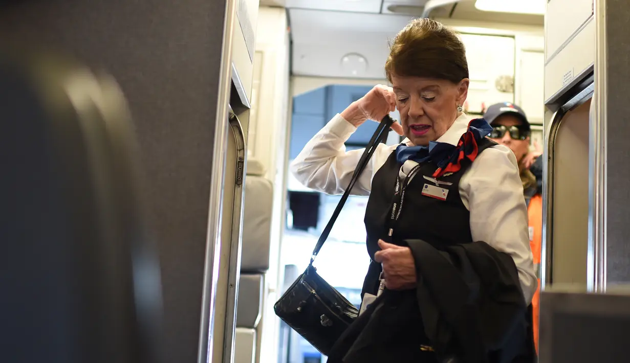 Pramugari tertua di maskapai American Airlines, Bette Nash membawa barang-barangnya sebelum melakukan penerbangan ke Boston di Bandara Ronald Reagan Washington di Arlington, Virginia (19/21). (AFP Photo/Eric Baradat)