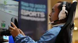 Seorang pebalap simulator berkompetisi saat Jakarta E-Prix ESports Championship 2023 yang berlangsung di Mal Artha Gading, Kelapa Gading, Jakarta Utara, Sabtu (20/05/2023).  40 pebalap simulator berpartisipasi untuk memperebutkan kejuaraan merupakan rangkaian dari Road to Jakarta E-Prix 2023. (Bola.com/Bagaskara Lazuardi)