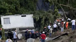 Tim penyelamat melakukan pencarian korban di sekitar rumah yang tertimbun tanah longsor di Santa Catarina Pinula, Guatemala (2/10/2015). Penyelamatan dan pencarian personil terus bekerja di daerah sampai saat ini. (REUTERS/Josue Decavele)