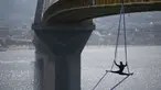 Seorang koreografer dan penari "ekstrem", Katerina Soldatou melakukan tarian di bawah jembatan Rio-Antirio, Yunani selatan, Senin (12/3).  Jembatan ini merupakan jembatan bentang kabel terpanjang di dunia. (AP Photo/Petros Giannakouris)
