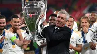 Carlo Ancelotti dan para pemain Real Madrid mengangkat trofi Liga Champions 2023/2024, Minggu (2/6/2024) dini hari WIB. (GLYN KIRK / AFP)