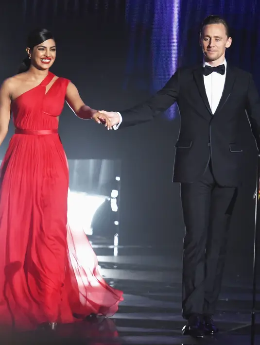 Yang membuat terlihat mereka romantic adalah perlakuan Tom yang menggenggam lengan Pryanka dengan erat sambil membisikan sesuatu di telinga Pryanka. (AFP/Bintang.com)