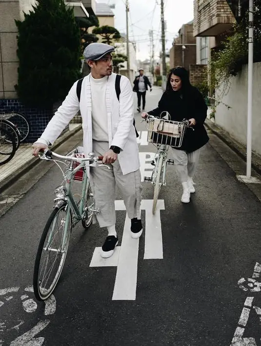 Masih di Jepang sepertinya. Kali ini keduanya benar-benar stylish banget dan bertemakan monokrom. Tarra dengan outfit putih dan newsboy cap abu-abu, Gya dengan parka hitam dan celana putih. Mereka sedang menuntun sepedanya. (Instagram/tarrabudiman)