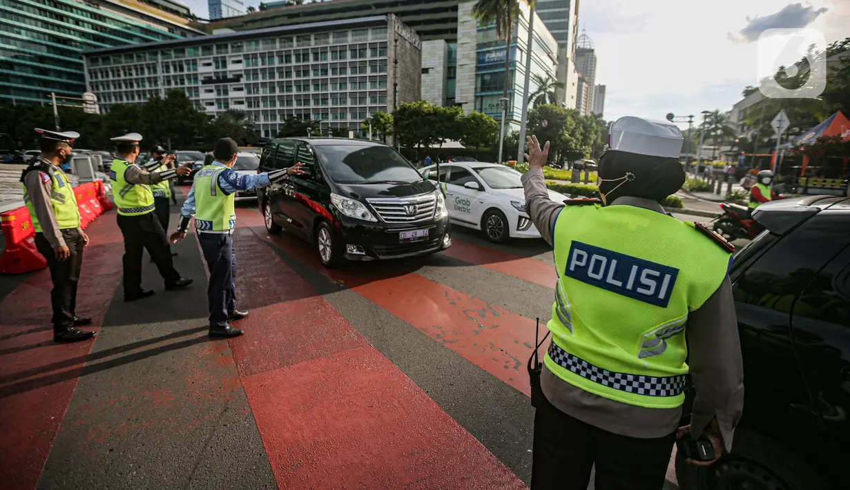 Petugas gabungan mengatur lalu lintas saat uji coba rekayasa lalu lintas di kawasan Bundaran HI, Jakarta Pusat, Senin sore (4/7/2022). Arus lalu lintas di sekitar Bundaran HI semakin padat dalam beberapa waktu terakhir hingga dilakukan rekayasa lalu lintas di sekitar lokasi. (Liputan6.com/Faizal Fanani)