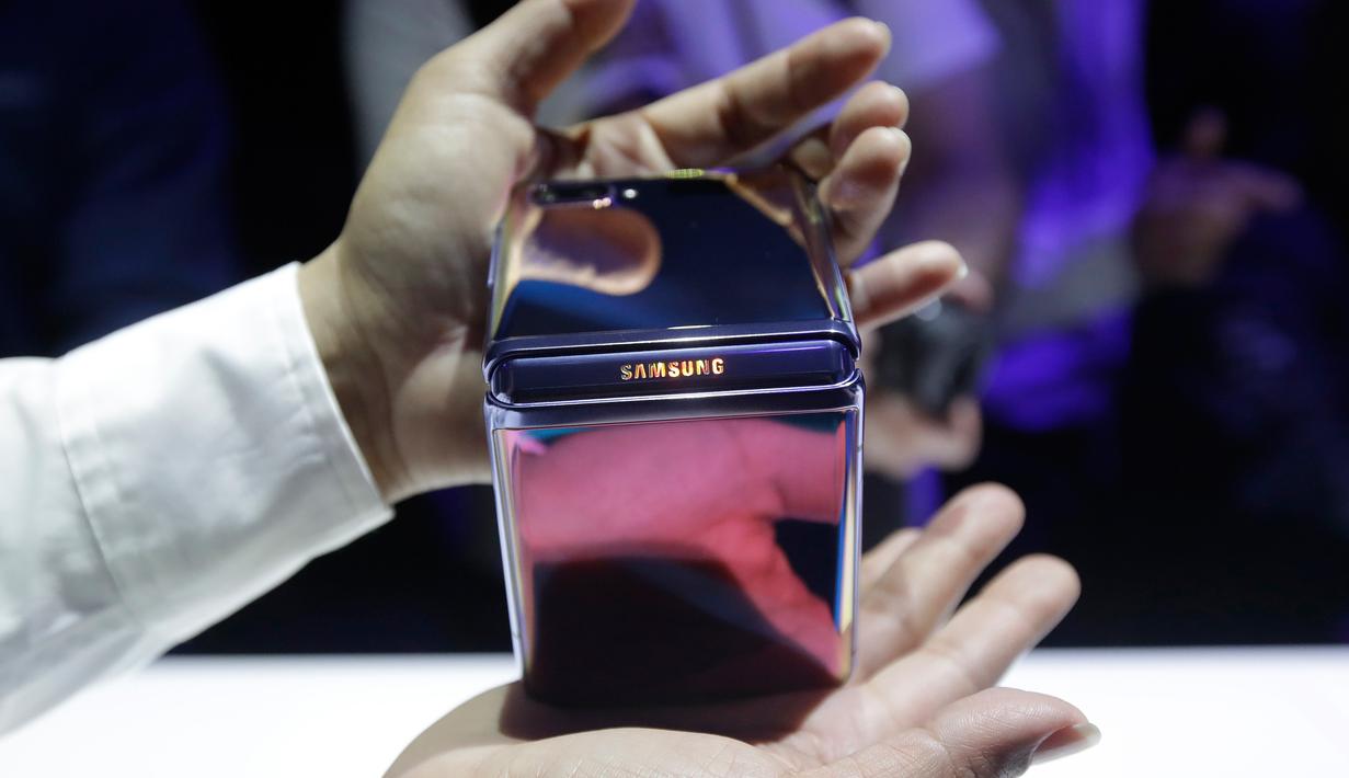Seorang pekerja Samsung mendemonstrasi Galaxy Z Flip yang ditampilkan pada acara Unpacked 2020 di San Francisco, Selasa (11/2/2020). Smartphone yang akan dijual di Amerika Serikat (AS) dan Korea pada 14 Februari 2020 tersebut dijual dengan harga $1.380 (Rp18,8 juta) . (AP/Jeff Chiu)