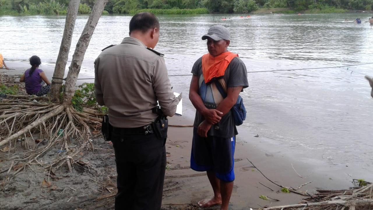 Seorang petugas kepolisian tengah melakukan identifikasi korban yang hilang di muara Sungai Cibaluk, Garut