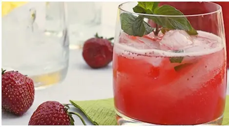 Segelas cocktail leci dengan hiasan daun mint dan potongan buah, sempurna untuk melepas dahaga di hari panas