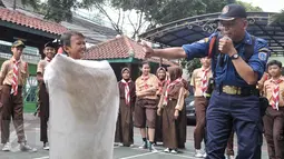 Seorang murid mencoba memadamkan api menggunakan karung basah, Jakarta, Rabu (14/9). Dinas Pemadam Kebakaran (Damkar) menggelar pelatihan singkat mengatasi kebakaran di SMPN 43 Mampang Prapatan. (Liputan6.com/Yoppy Renato)